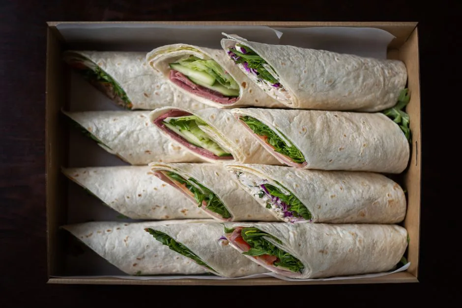 Appetizing wraps arranged in a box, showcasing fresh ingredients from a top view.