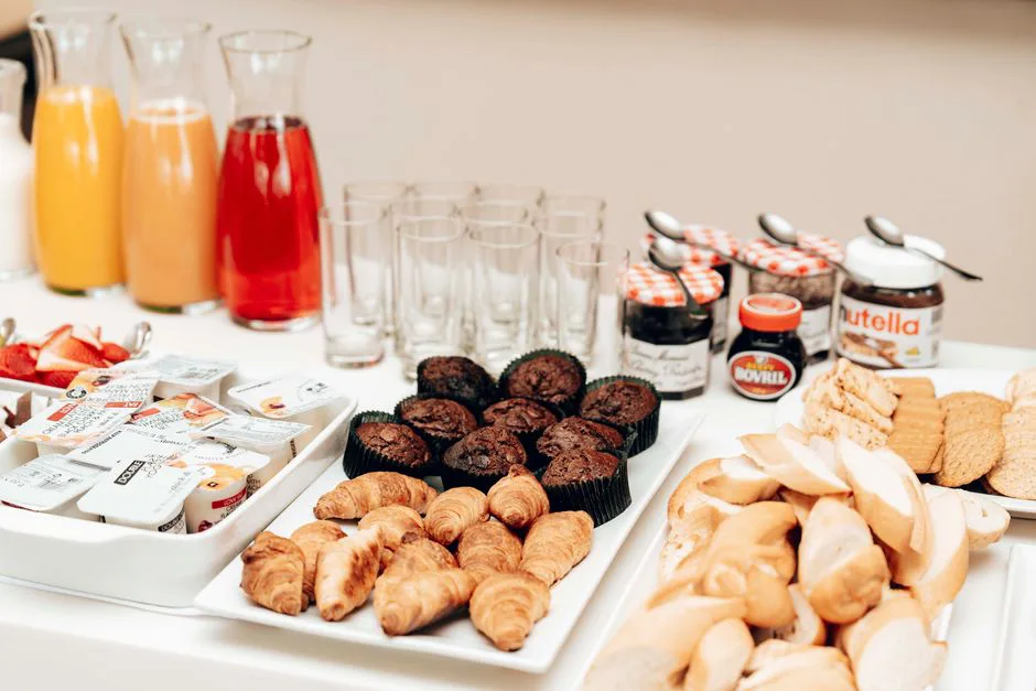 An enticing breakfast buffet with croissants, muffins, bread, juices, and spreads, perfect for a refreshing start to the day.
