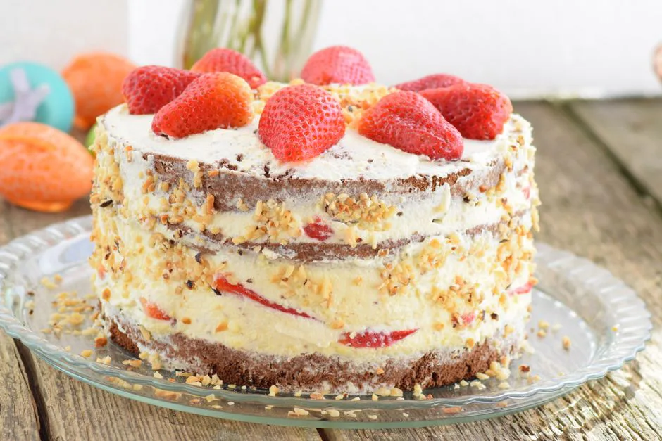 Delicious strawberry-layered cake with cream and nuts on a rustic wooden table. Perfect for dessert enthusiasts.