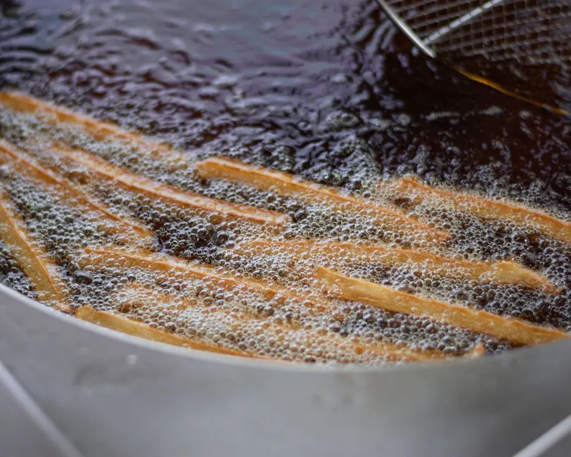 Close-up of French fries being deep-fried in hot oil. Perfect for food enthusiasts.