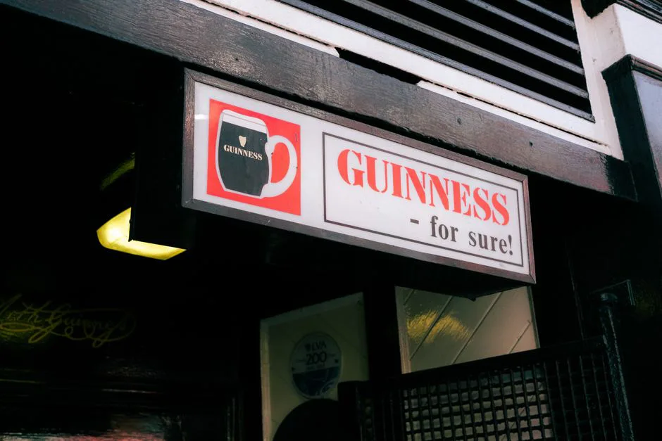A vintage Guinness sign outside a pub with classic wooden decor.