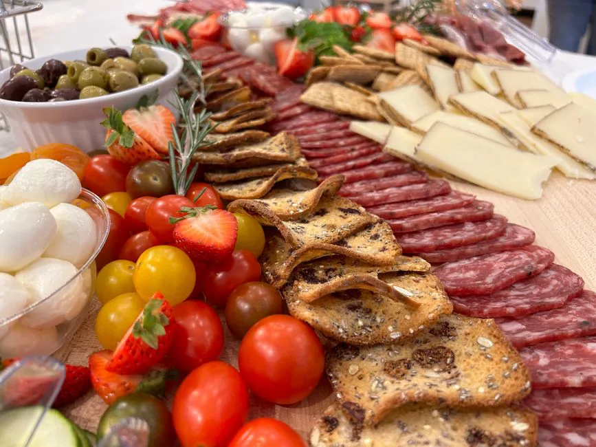 A vibrant charcuterie board featuring cheese, meats, crackers, and fresh fruits.