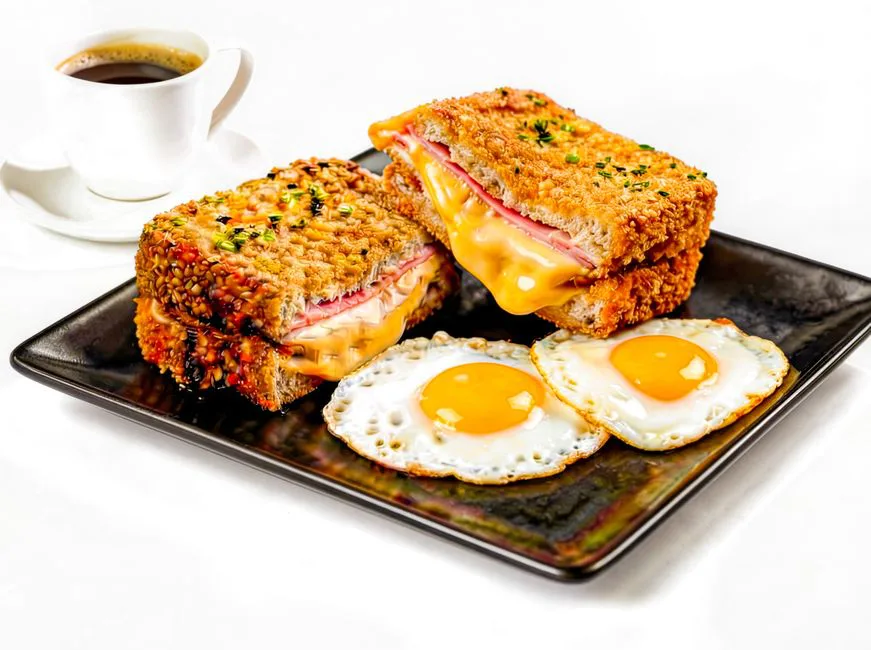 Savor a crispy Croque Monsieur paired with sunny-side-up eggs and coffee.
