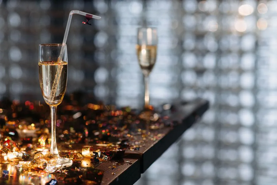 Elegant champagne glasses on a table with festive confetti, creating a celebratory atmosphere.