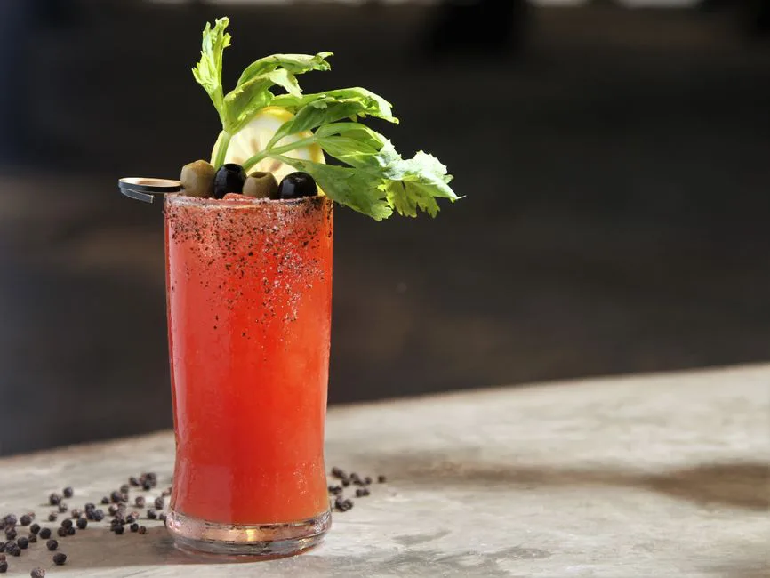 Close-up of a Bloody Mary cocktail with celery, olives, and lemon garnish, perfect for any brunch setting.