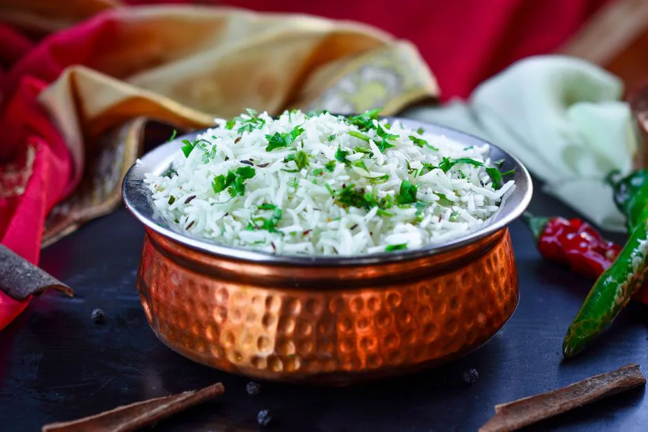 Delicious fragrant basmati rice garnished with fresh herbs in an ornate copper bowl, capturing Jordanian cuisine.