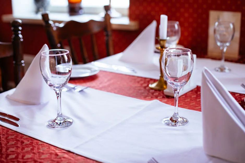 Sophisticated table setting with wine glasses and candles in a cozy restaurant.