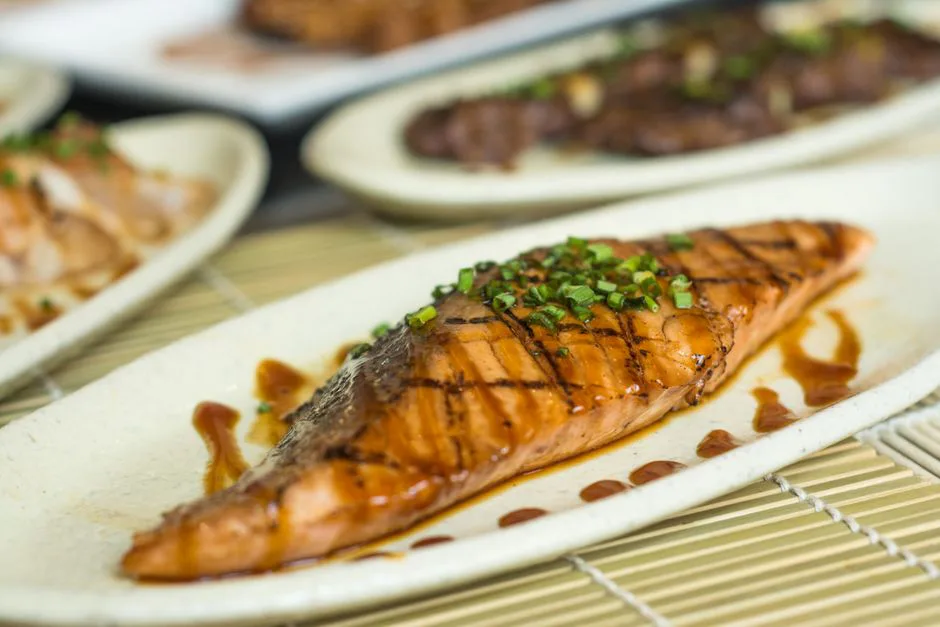 Delicious grilled salmon fillet drizzled with soy sauce and garnished with green onions.