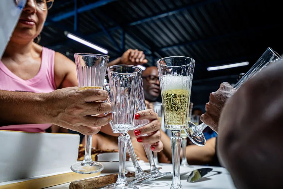 A joyful moment of clinking champagne glasses at a social gathering indoors.