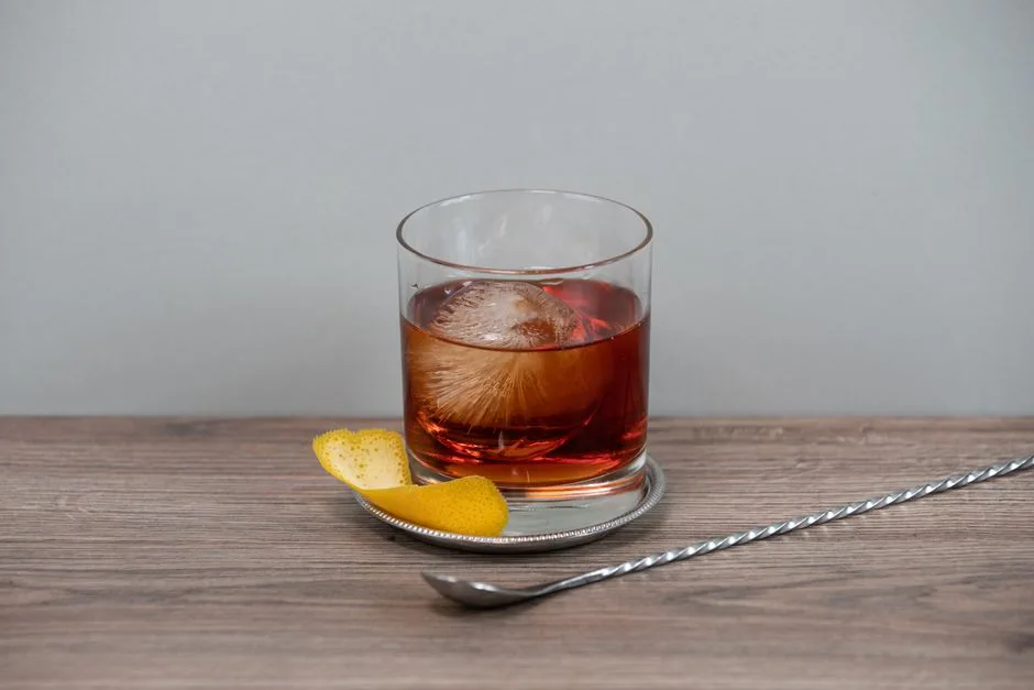 A classic whiskey cocktail with an ice sphere and citrus peel, perfect for refined settings.