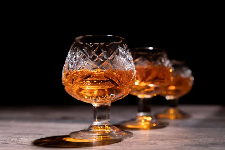 Close-up of crystal glasses filled with whiskey, showcasing elegant design and selective focus.