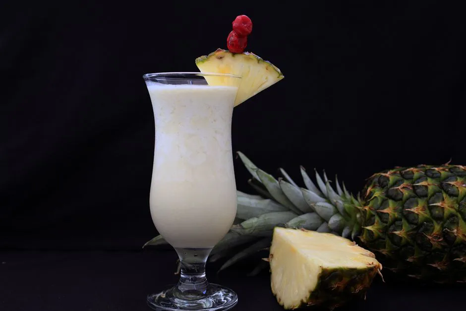 A refreshing pina colada garnished with fresh pineapple slices, ideal for tropical settings.