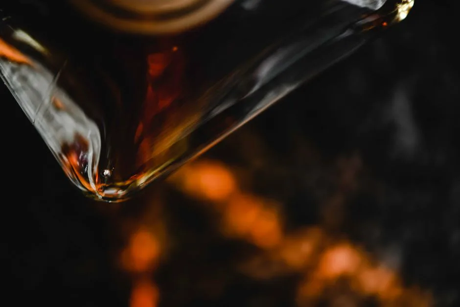 A close-up of a whiskey bottle, highlighting amber hues against a dark background.