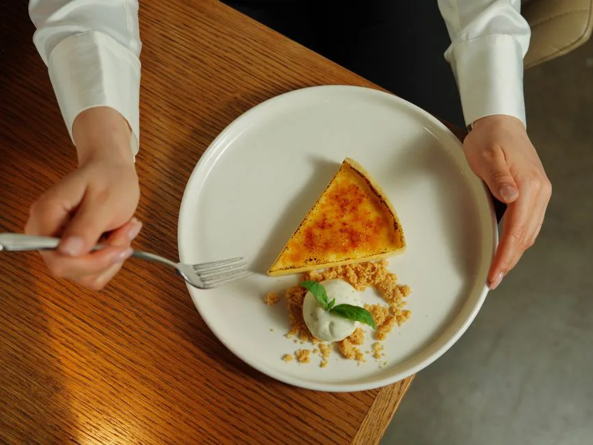 Elegant presentation of crème brûlée tart with ice cream on a plate.