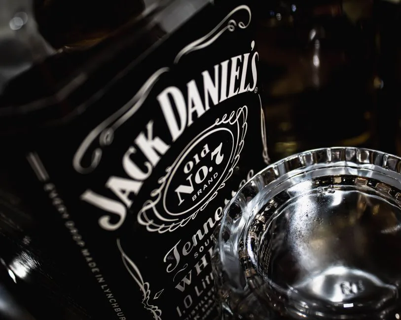 Detailed view of a Jack Daniel's whiskey bottle with glass, highlighting the brand's iconic label.